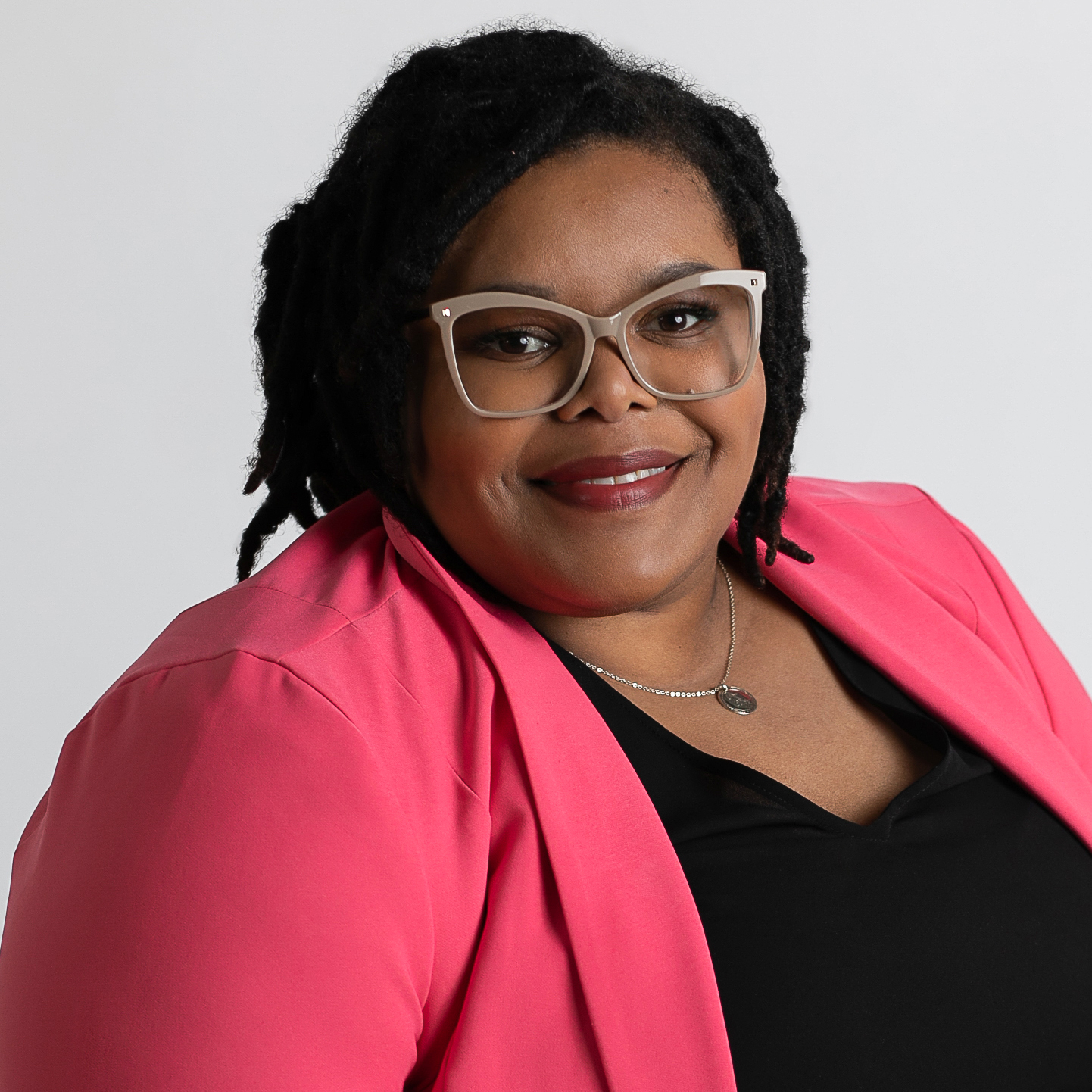 Sadé Lancaster wearing a bright pink blazer.